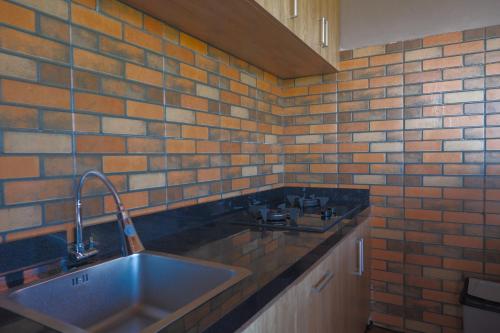 uma cozinha com um lavatório e uma parede de tijolos em Gama’s Villa em Tabanan
