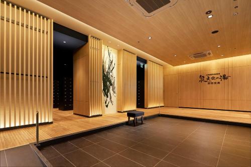 a lobby with wood paneling and a chair in a building at Villa Fontaine Premier Haneda Airport in Tokyo