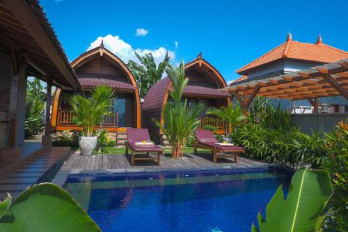 a villa with a swimming pool in front of a house at Gama’s Villa in Tabanan