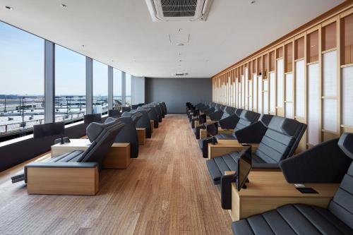 a row of chairs in a room with windows at Villa Fontaine Premier Haneda Airport in Tokyo