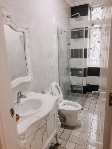 uma casa de banho branca com um lavatório e um WC em thiên phú hotel em Ho Chi Minh