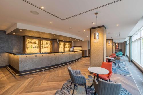 a lobby with a bar and tables and chairs at Radisson Blu Hotel Erfurt in Erfurt