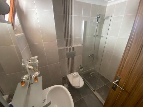 a bathroom with a toilet and a glass shower at Astoria Beach Hotel in Marmaris