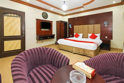 um quarto de hotel com uma cama e duas cadeiras em OYO 589 Lavina House em Jeddah