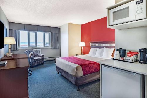 a hotel room with a bed and a desk at Travelodge by Wyndham Fort St John in Fort Saint John