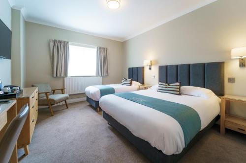 a hotel room with two beds and a television at Aberystwyth Park Lodge Hotel in Aberystwyth