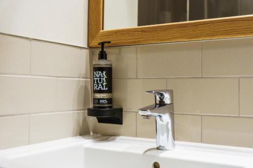 a bathroom sink with a bottle of hand soap on it at Aberystwyth Park Lodge Hotel in Aberystwyth