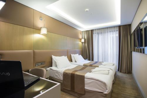 イスタンブールにあるGK リージェンシー スイーツ ホテルのベッド2台とノートパソコンが備わるホテルルームです。