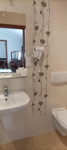 a bathroom with a sink and a toilet at Hotel Przylesie in Sierosław