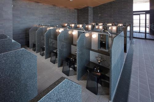 a row of urinals in a public restroom at Villa Fontaine Grand Haneda Airport in Tokyo