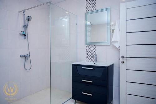 bagno con doccia, lavandino e specchio di Welcome Inn Hotel a Yerevan