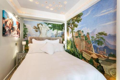 ein Schlafzimmer mit einem großen weißen Bett mit einem Gemälde in der Unterkunft LUXURY BEACH PROPERTY- Neptune's Nest in Sandgate