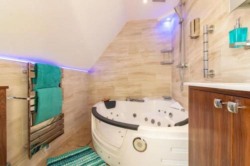 ein Badezimmer mit einer weißen Badewanne und einem Waschbecken in der Unterkunft LUXURY BEACH PROPERTY- Neptune's Nest in Sandgate