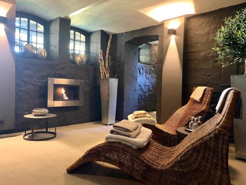 een woonkamer met rieten stoelen en een open haard bij country-suites by verdino LIVING - Apartments & Suites in Braunlage