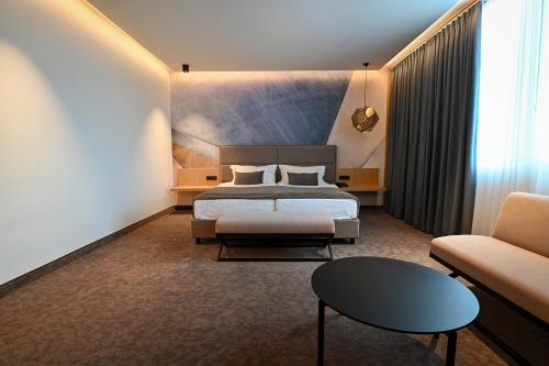 a hotel room with a bed and a couch at Safir Hotel Casino in Sežana