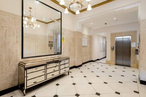 a bathroom with a large mirror and a tiled floor at Spacious and luxe two king bedroom sea-view apt in Brighton & Hove