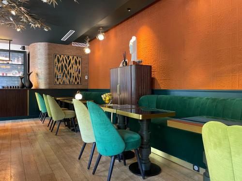 a dining room with a table and green chairs at ELSA, Hôtel Paris in Paris