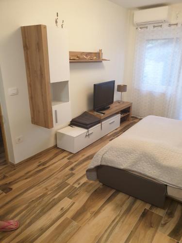a bedroom with a bed and a desk with a television at Apartment with terrace in Portorož