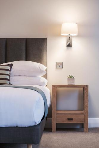 a bedroom with a bed and a table with a lamp at Aberystwyth Park Lodge Hotel in Aberystwyth