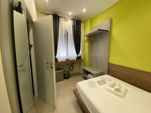 a small room with a bed and a window at Levante apartment and room in Bari