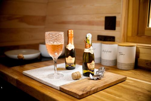 two bottles of champagne and a glass on a table at Cliff Stud Retreat - Luxury lodges and cosy cottages in Helmsley
