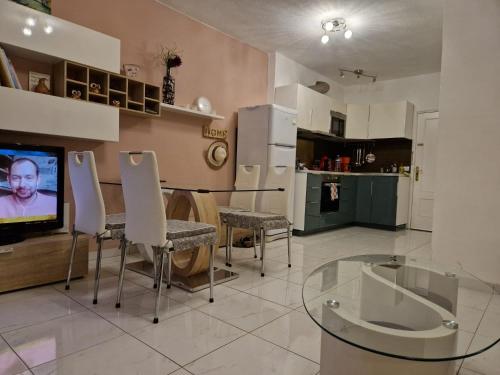 a living room with a glass table and a kitchen at Soleil et Océan in Playa Paraiso