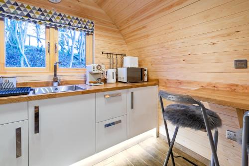 a kitchen with a sink and a counter with a chair at Cliff Stud Retreat - Luxury lodges and cosy cottages in Helmsley