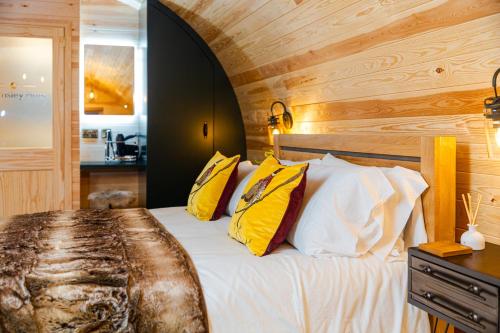 a bedroom with a bed with yellow and white pillows at Cliff Stud Retreat - Luxury lodges and cosy cottages in Helmsley