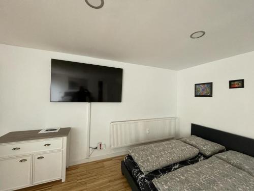 - une chambre avec un lit et une télévision à écran plat dans l'établissement Bungalow mit Terrasse, à Ratisbonne