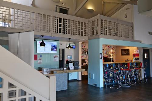 a restaurant with a bar and stools in a room at ibis Moulins in Moulins