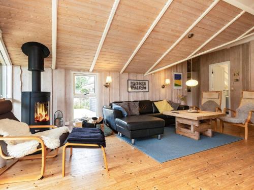sala de estar con sofá y chimenea en 9 person holiday home in L kken en Trudslev