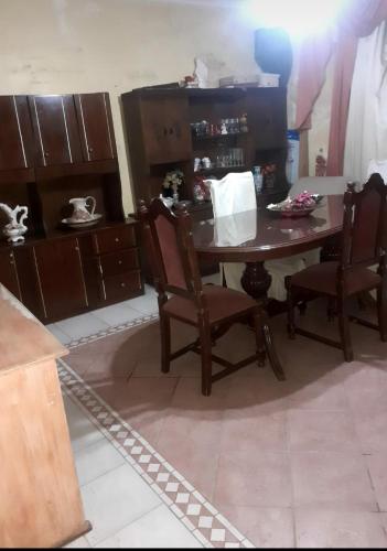 uma cozinha com uma mesa de madeira e 2 cadeiras em Avellaneda la banda em La Banda