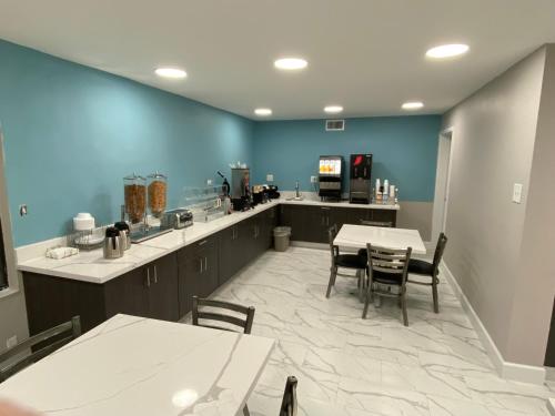 a kitchen with tables and chairs and a blue wall at Days Inn by Wyndham Waco University Area in Waco
