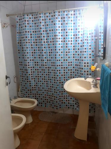 a bathroom with two toilets and a blue shower curtain at Avellaneda la banda in La Banda