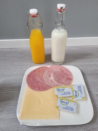 a plate of cheese and meat and bottles of milk at B&B Mooi Betuwe in Tiel