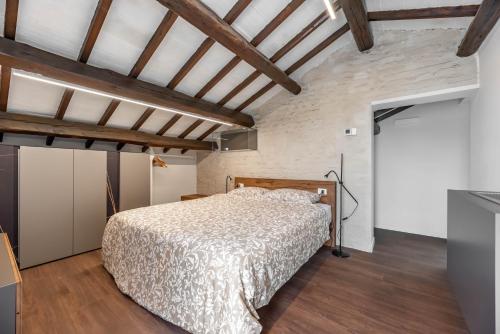 una camera con letto in una stanza con soffitti in legno di Palazzo '900 Design Flats - Il Prato a Padova