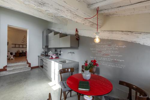 una cocina con una mesa roja con sillas y una barra en LA TULIPA, en San Quirico dʼOrcia