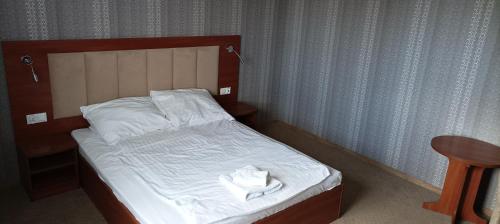 a bed with white towels on it in a room at Hotel Przylesie in Sierosław