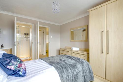 Ashford, Legoland, Windsor, Heathrow Serviced House في ستانويل: غرفة نوم بسرير ابيض وخزانة