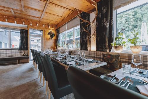 a long table in a restaurant with green chairs at Der Gollinger in Saalbach Hinterglemm