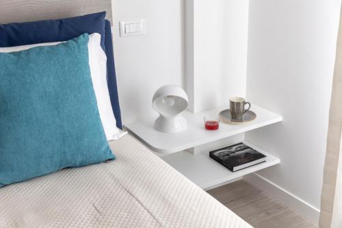 a bed with a blue pillow and a side table at La Musa Apartments & Rooms in Palermo