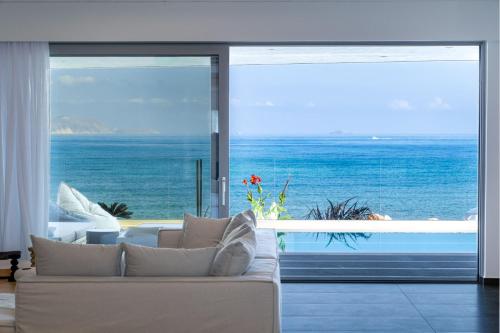 un soggiorno con divano e vista sull'oceano di Dia's Blue Villa a Gournes
