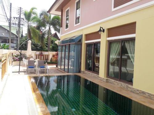 a swimming pool in front of a house at 4BD Private pool villa in Patong heart quiet&nice in Patong Beach