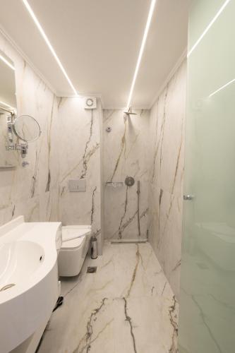a bathroom with a sink and a toilet and a shower at Modern Revival Luxury Hotel in Thessaloniki