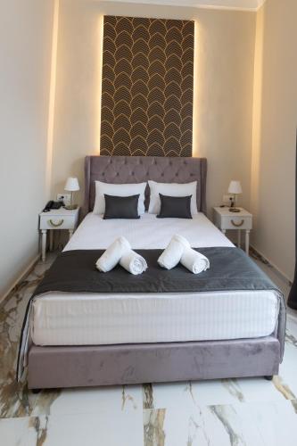 a bedroom with a large bed with two pillows at Modern Revival Luxury Hotel in Thessaloniki