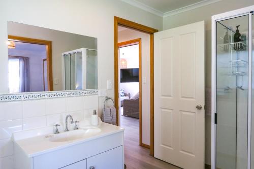 a bathroom with a sink and a mirror at Bridgecroft Beach Shack blissful spa retreat for 6 in Port Arthur