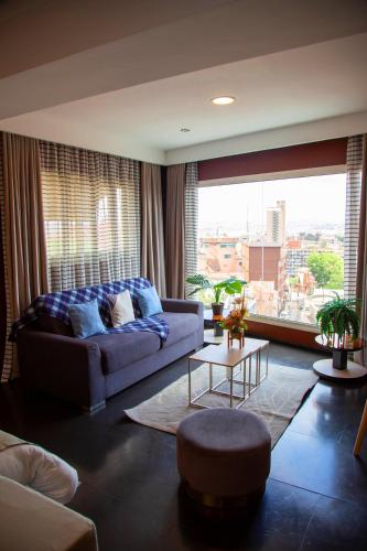 a living room with a couch and a large window at Hotel La Villette in Antananarivo
