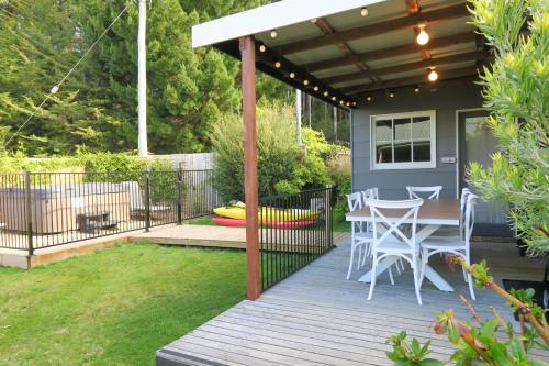 a patio with a table and chairs on a deck at Radcliffe Retreat and Spa Cottage Port Arthur in Port Arthur