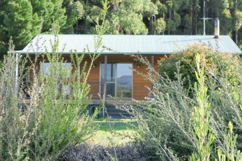 a wooden house with a metal roof at Radcliffe Retreat and Spa Cottage Port Arthur in Port Arthur