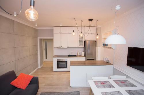 eine Küche und ein Wohnzimmer mit weißen Schränken in der Unterkunft Duży apartament w centrum przy rynku in Białystok